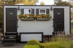 Black Tie Luxury restroom trailers exterior with vinyl siding, light fixtures, flower boxes, windows and dark trim