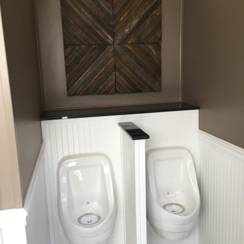Black Tie restroom trailer luxury interior with trim, wood paneling and painted walls